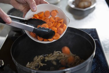 Mettez les légumes et les herbes aromatiques dans le faitout.