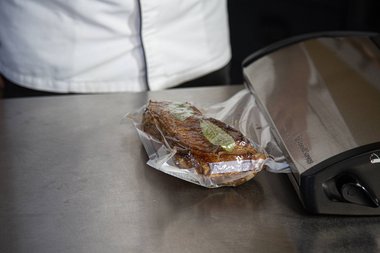 Scellez la viande de veau dans un sachet de cuisson sous vide avec des herbes aromatiques et des épices.